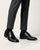 Regal Black worn with gray pants on a white background