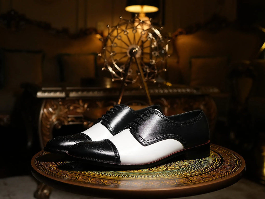 Editorial shot of Bold Brogue black and white dress shoes styled with suit in urban setting representing luxury formal footwear