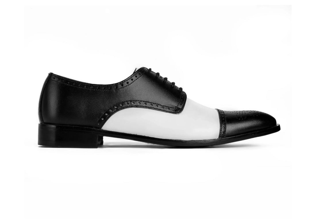 Side profile of Bold Brogue dress shoes showing black and white contrast design with elegant formal silhouette