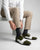 Ebony and Ivory brogue shoes styled with formal outfit in sitting lifestyle shot showcasing bold menswear fashion