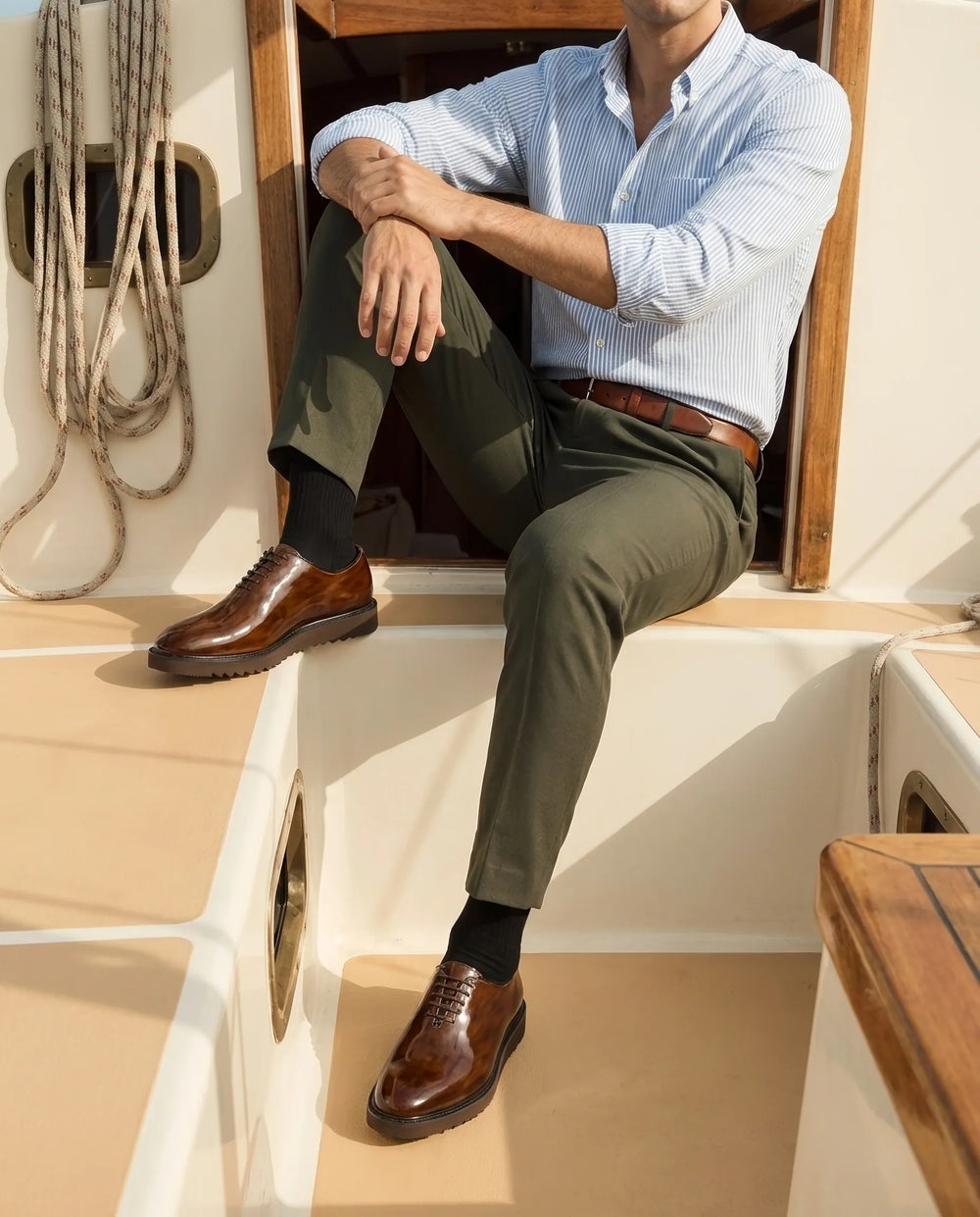 Man wearing polished brown leather brogue shoes aboard a yacht in Salcombe in the afternoon